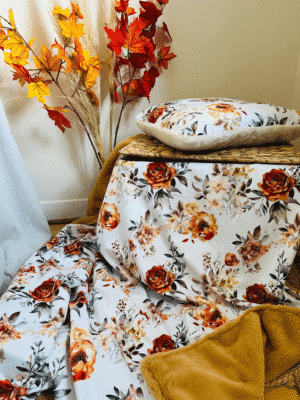 Plaid cocooning automnal 150x150 cm ou 200x150 cm. Motifs fleuris aux tons chauds, doublure fausse fourrure miel. Tissu doudou ultra doux, personnalisable, édition limitée.