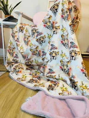 Plaid maxi douceur fait main, double face doudou et fausse fourrure synthétique. Motif léopard fleuri, deux tailles au choix, verso rose poudré ou marron, personnalisable. Plaid cocooning ultra doux.