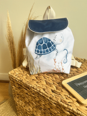 Sac à dos enfant imperméable tortue personnalisé avec prénom. Modèle artisanal en stock, format 35x35 cm, fermeture par cordon coulissant, poche intérieure zippée et bretelles réglables. Création exclusive Les Créa de Jenni.