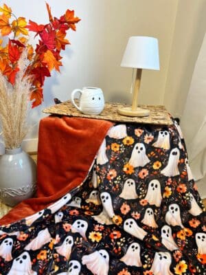 Craquez pour ce plaid Halloween Fantômes & Fleurs 200x150 cm, cousu main avec un doudou terracotta ultra doux. Environ 2 kg de douceur. En stock.